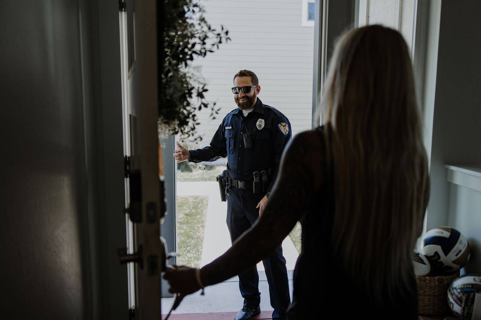 Police officer and woman opening door