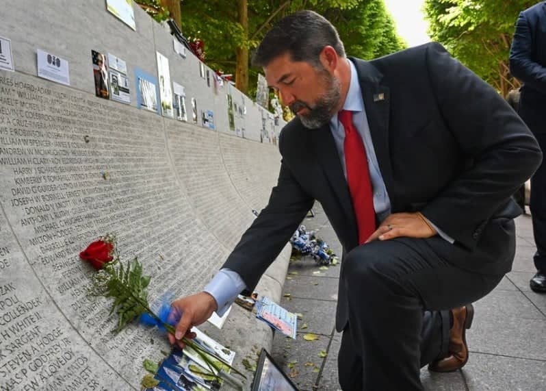 Officer placing rose on National Law Enforcement Officers Memrorial Wall