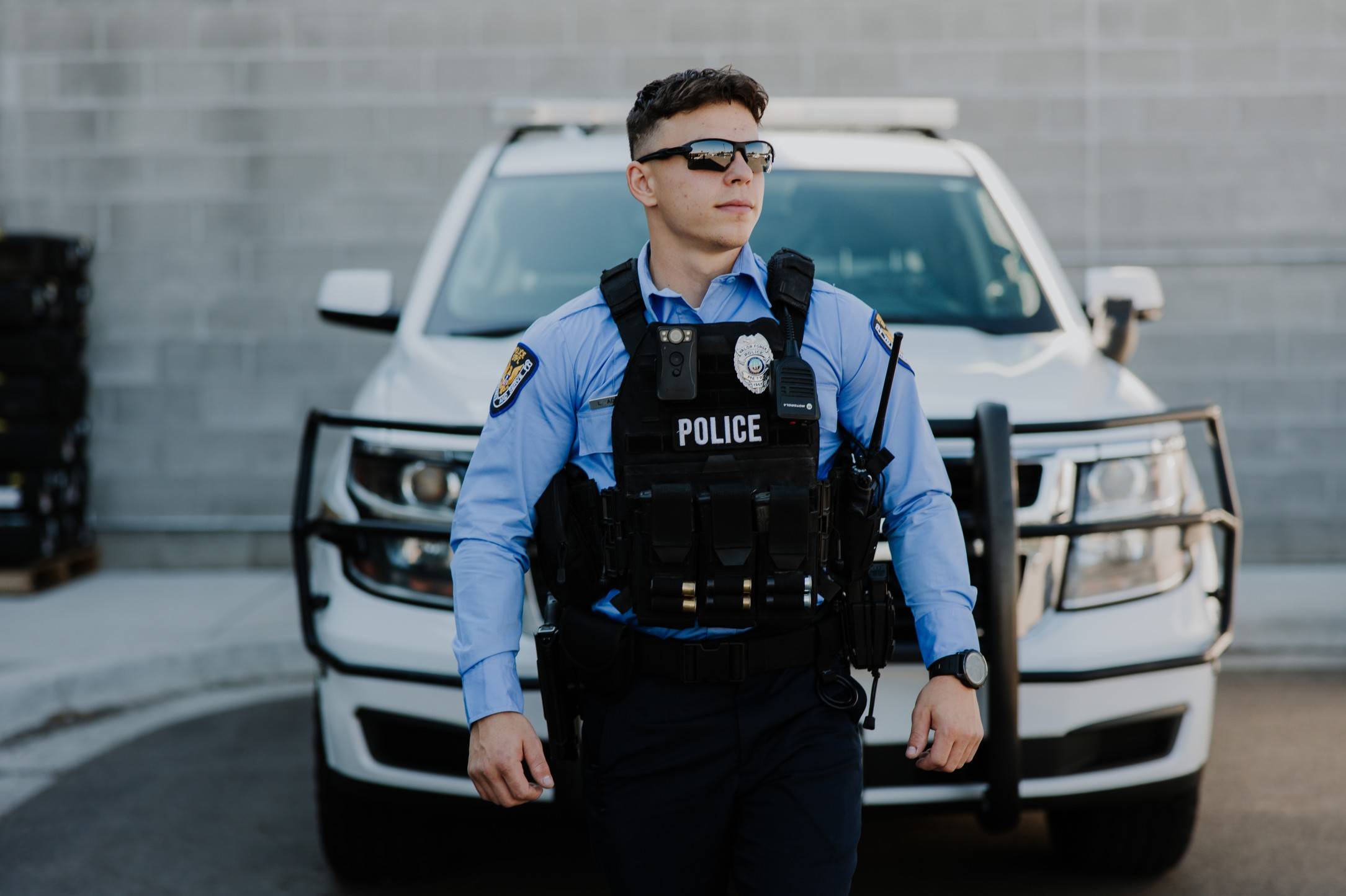Police officer standing in front of squad car