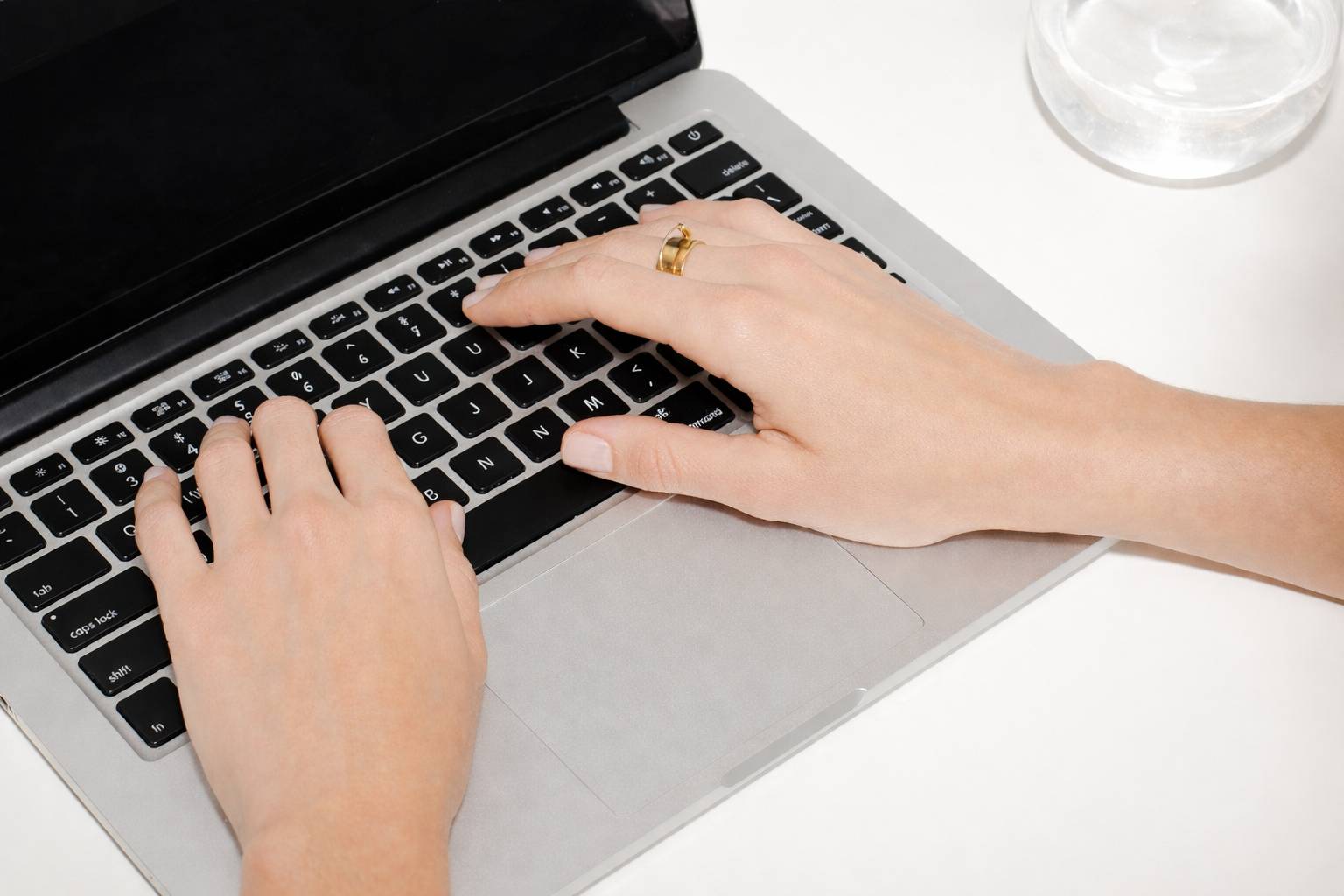 Hands typing on laptop